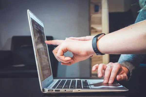 Dve osobe zajedno popunjavaju podatke na laptopu